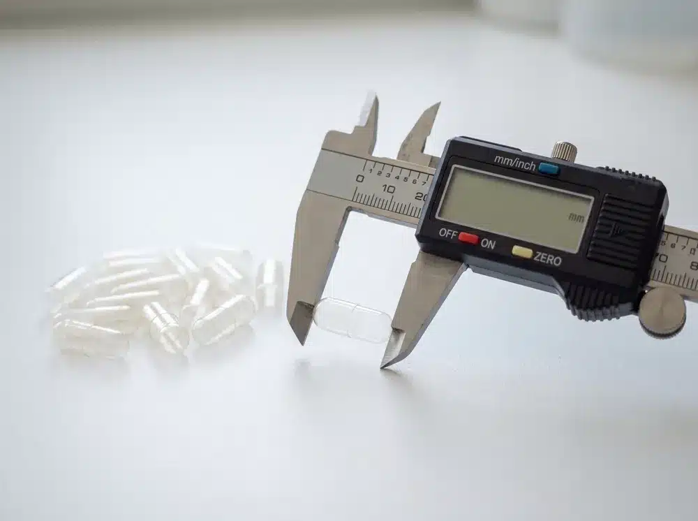size-00-capsule-dimensions-caliper Size 00 capsule measured with a digital caliper for length and diameter